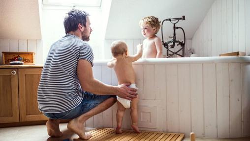 Father with toddlers in bath