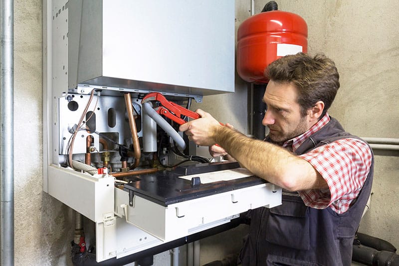 man repairing condensing boiler