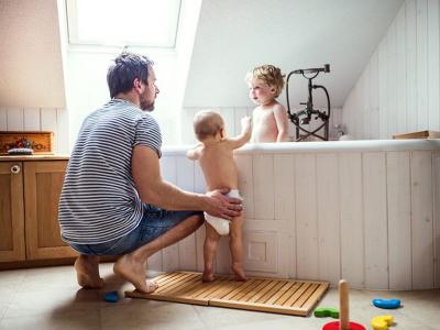 Father with toddlers in bath