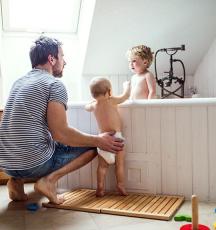 Father with toddlers in bath