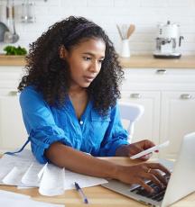 Women in kitchen with laptop