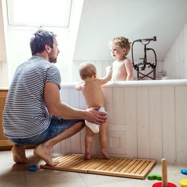 Father with toddlers in bath
