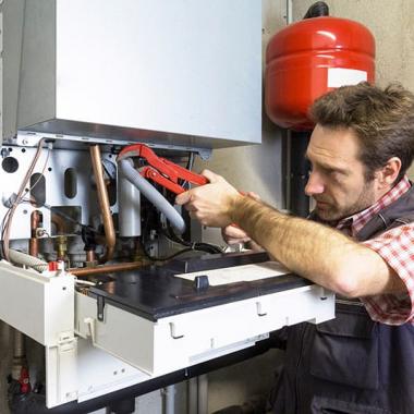 man repairing condensing boiler