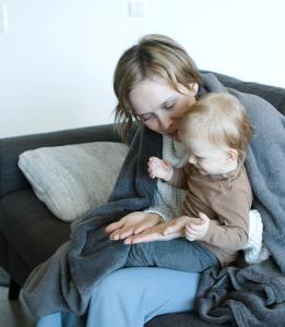 Woman with baby on sofa with blanket